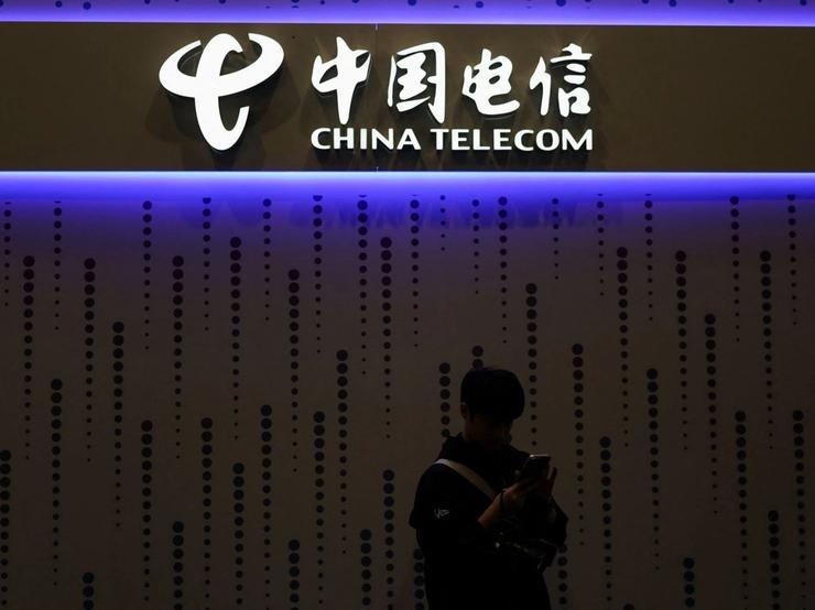 A visitor looks at his mobile at the China Telecom stand in the Mobile World Congress (MWC) in Barcelona, Spain