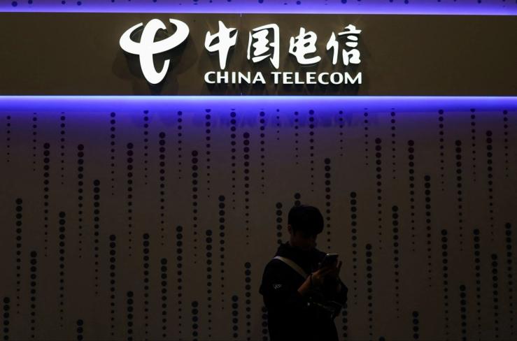 A visitor looks at his mobile at the China Telecom stand in the Mobile World Congress (MWC) in Barcelona, Spain