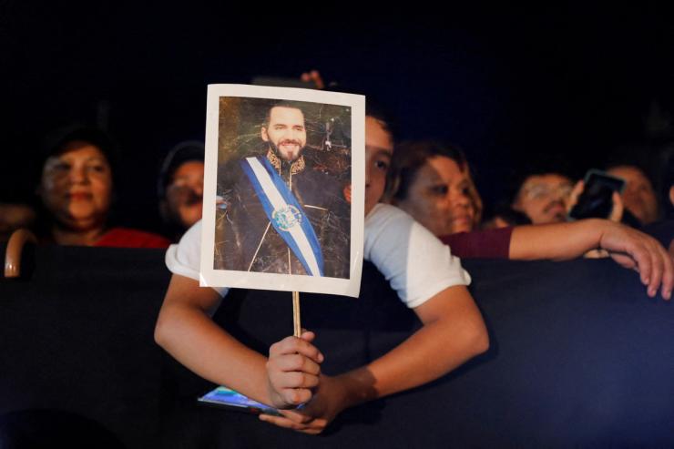 A boy holds an image of Nayib Bukele