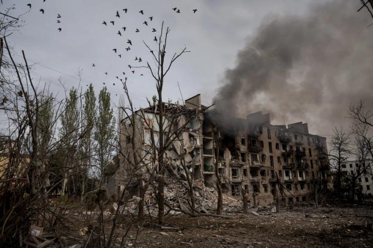 Smoke rises from apartment buildings damaged by Russian military strikes