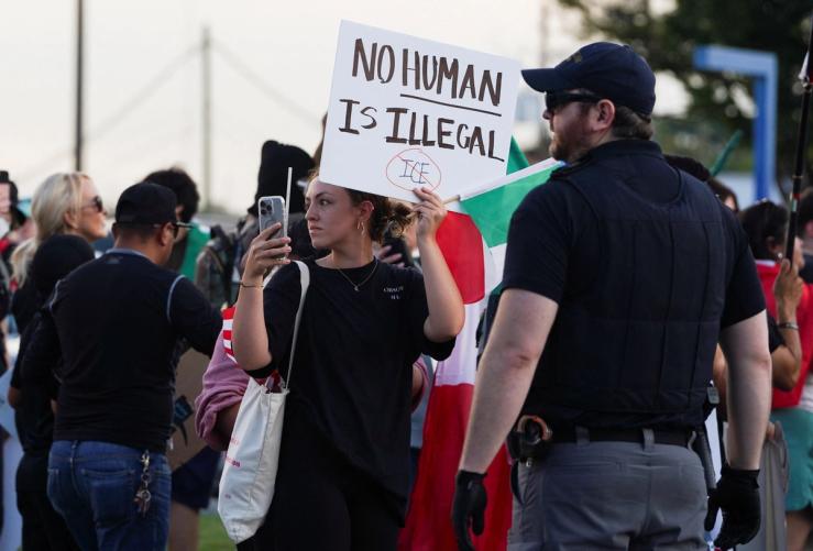 A demonstrator holds a sign during a protest against federal immigration sweeps, in Atlanta, Georgia.