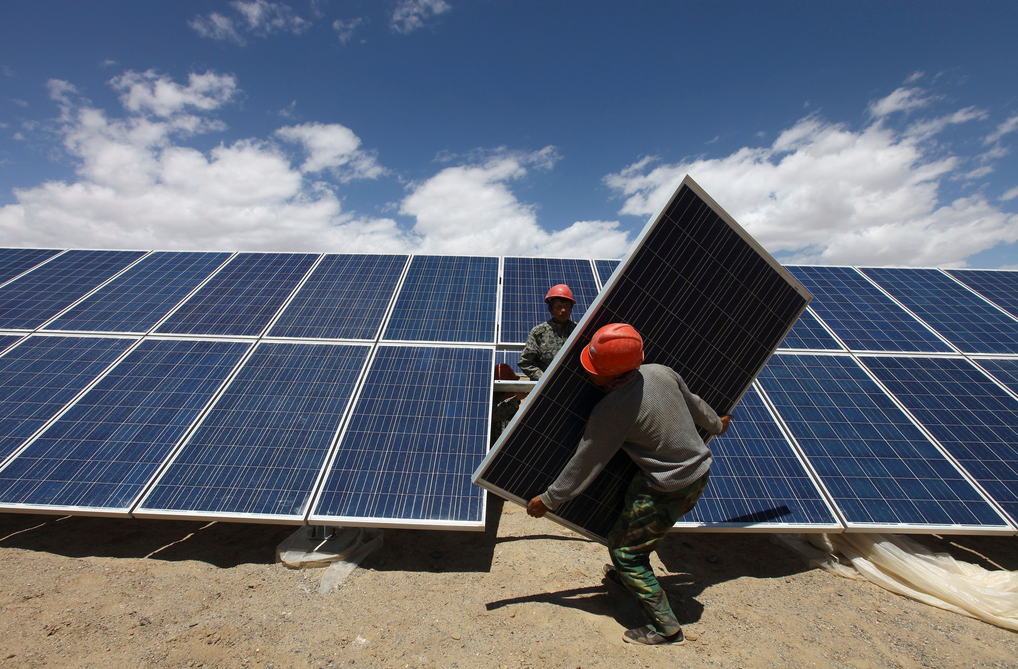 Workers install a solar panel in Jiuquan.