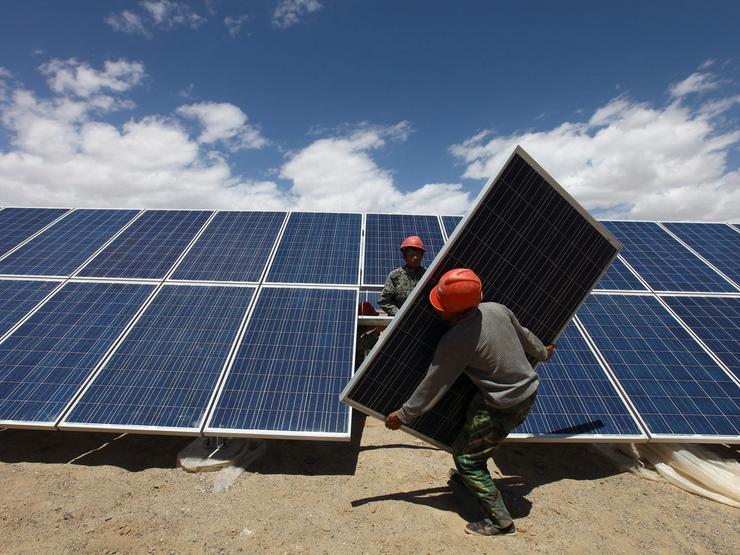 Workers install a solar panel in Jiuquan.