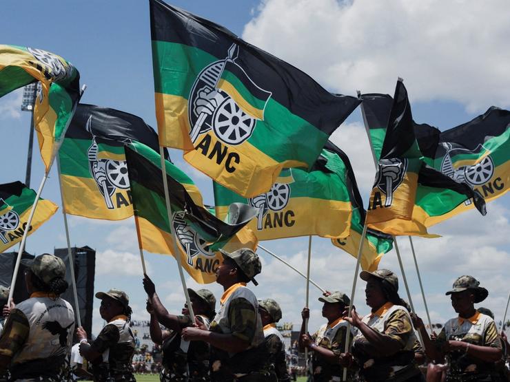 African National Congress supporters hold flags during the ANC’s anniversary celebration.