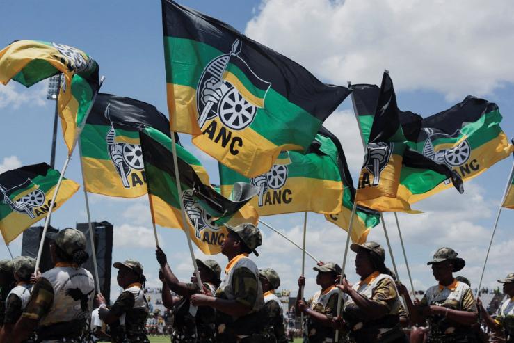 African National Congress supporters hold flags during the ANC’s anniversary celebration.