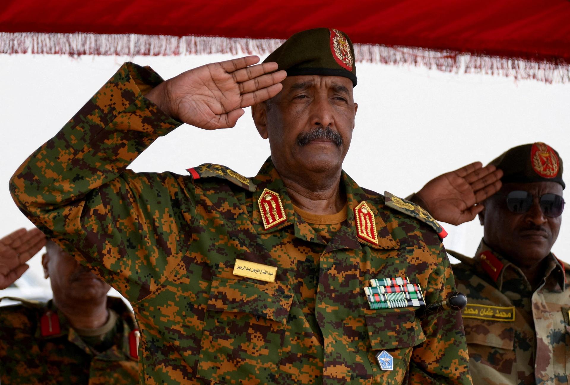 Sudanese General Abdel Fattah al-Burhan salutes as he listens to the national anthem