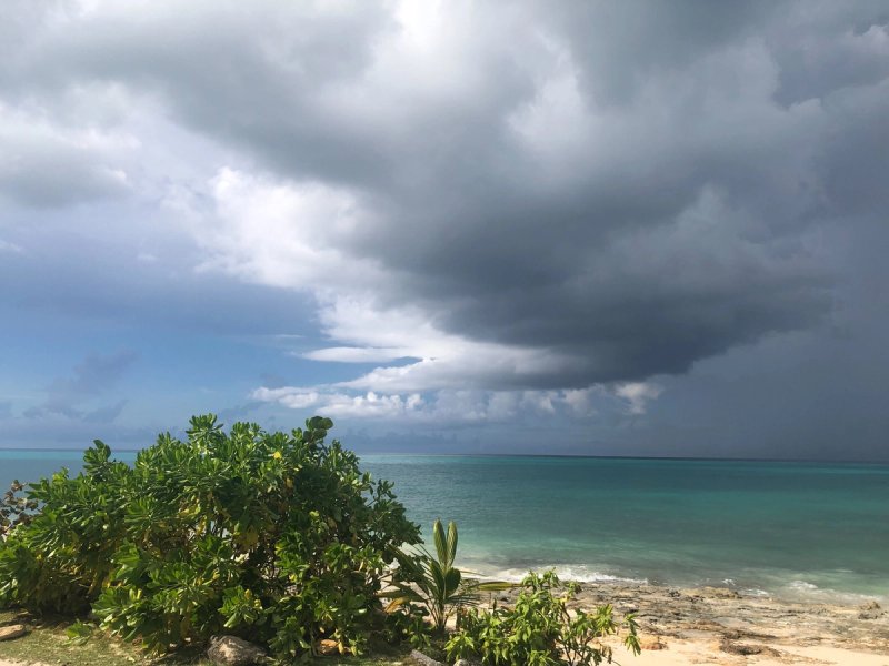 A storm cloud hangs over a beach in the Bahamas