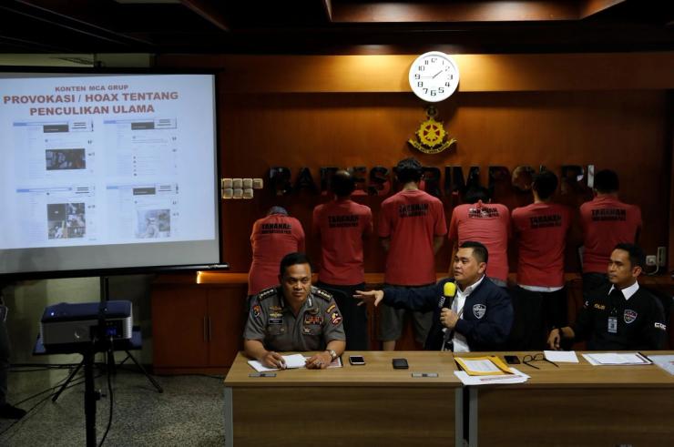 Indonesia’s cyber crime police holding a press conference in 2018, in front of a row of suspects.