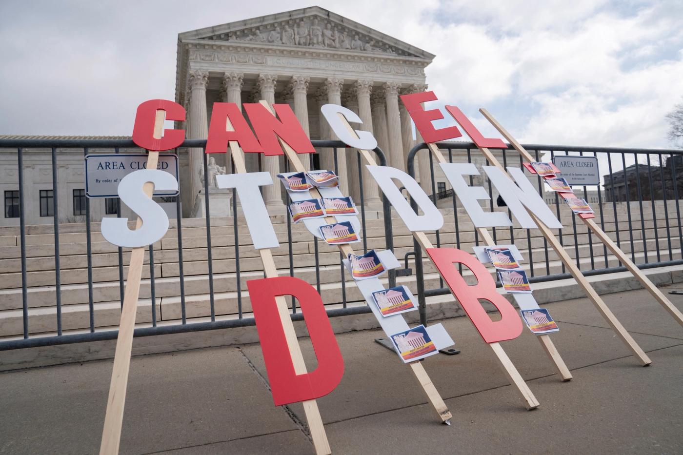 A sign calling for student loan debt relief is seen in front of the Supreme Court.