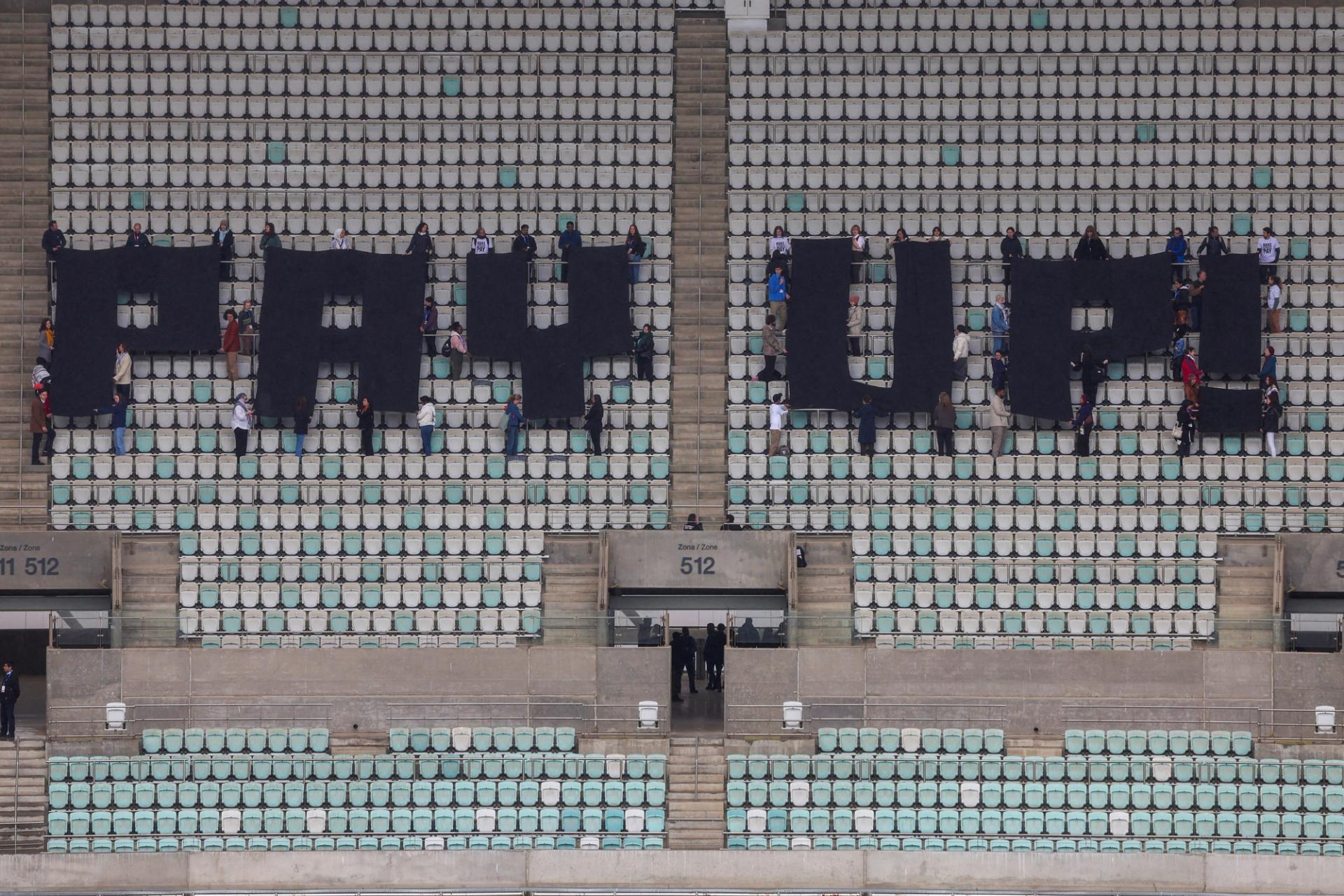 Activists hold a protest calling on developed nations to provide financing to fight climate change at the Olympic Stadium housing the United Nations climate change conference COP29 in Baku