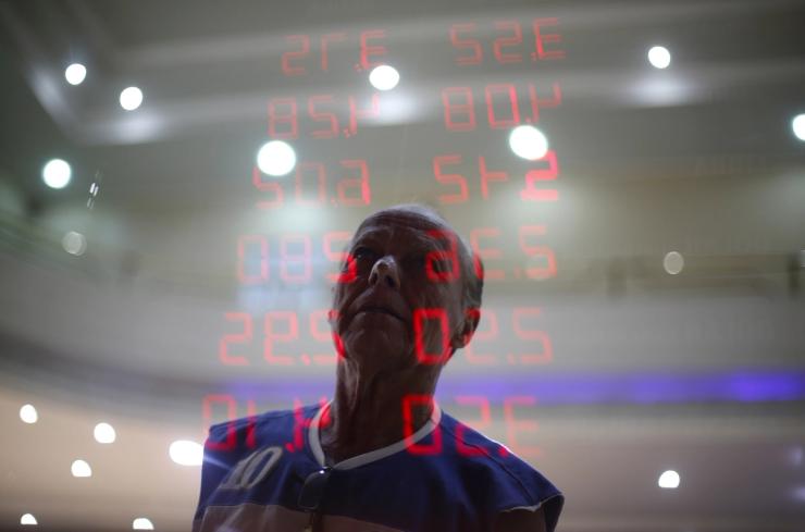 A man reacts as he reads a board showing the Real-U.S. dollar and several foreign currencies exchange rates in Rio de Janeiro, Brazil.