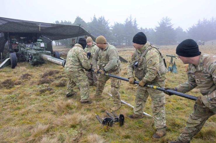 US soldiers clean a weapon during a military exercise in Denmark.