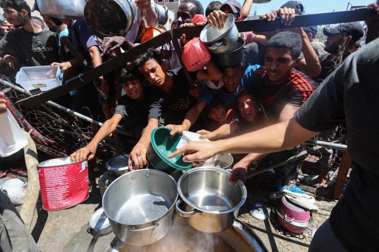 Palestinians gather to receive food from a charity kitchen.