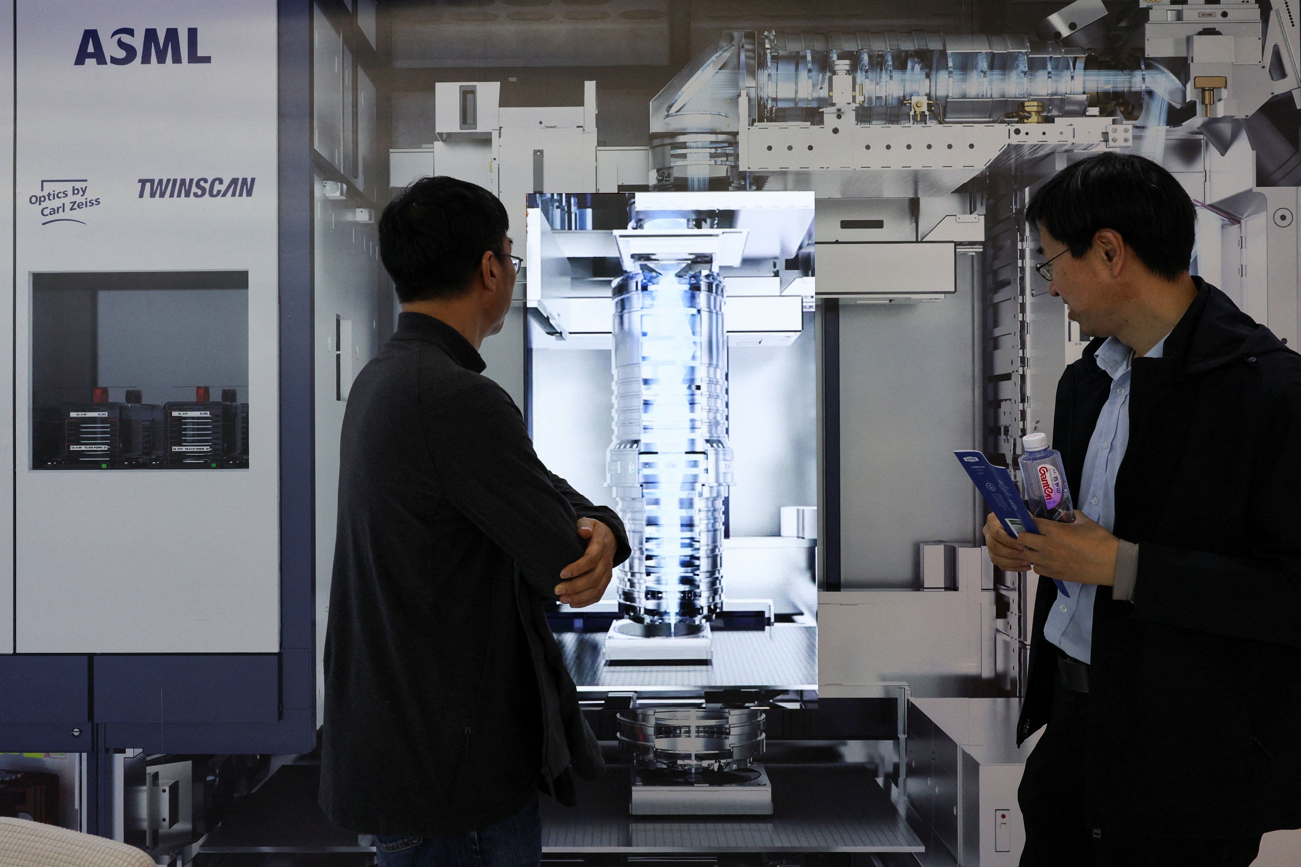 People visit the ASML booth during SEMICON China, a trade fair for semiconductor technology, in Shanghai.