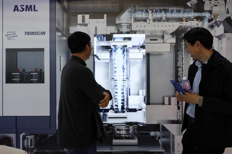 People visit the ASML booth during SEMICON China, a trade fair for semiconductor technology, in Shanghai.