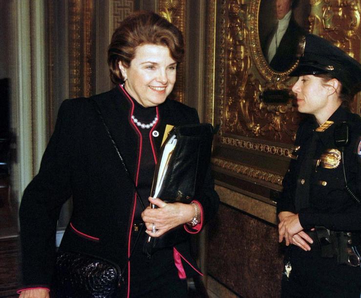 Senator Diane Feinstein (D-CA) walks past a guard at the U.S. Capitol on her way to the impeachment trial of President Clinton in Washington.