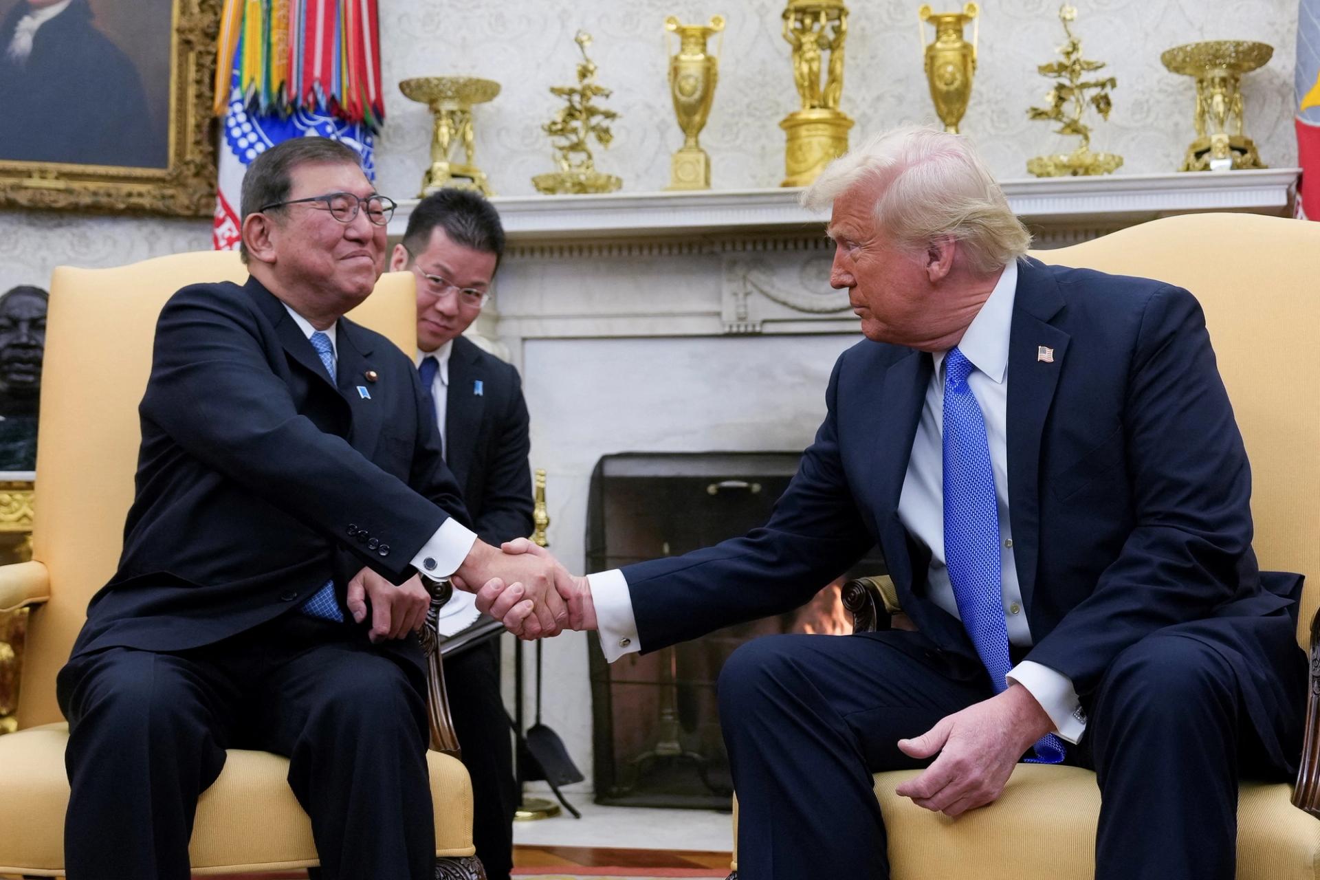 U.S. President Donald Trump shakes hands with Japan’s Prime Minister Shigeru Ishiba.