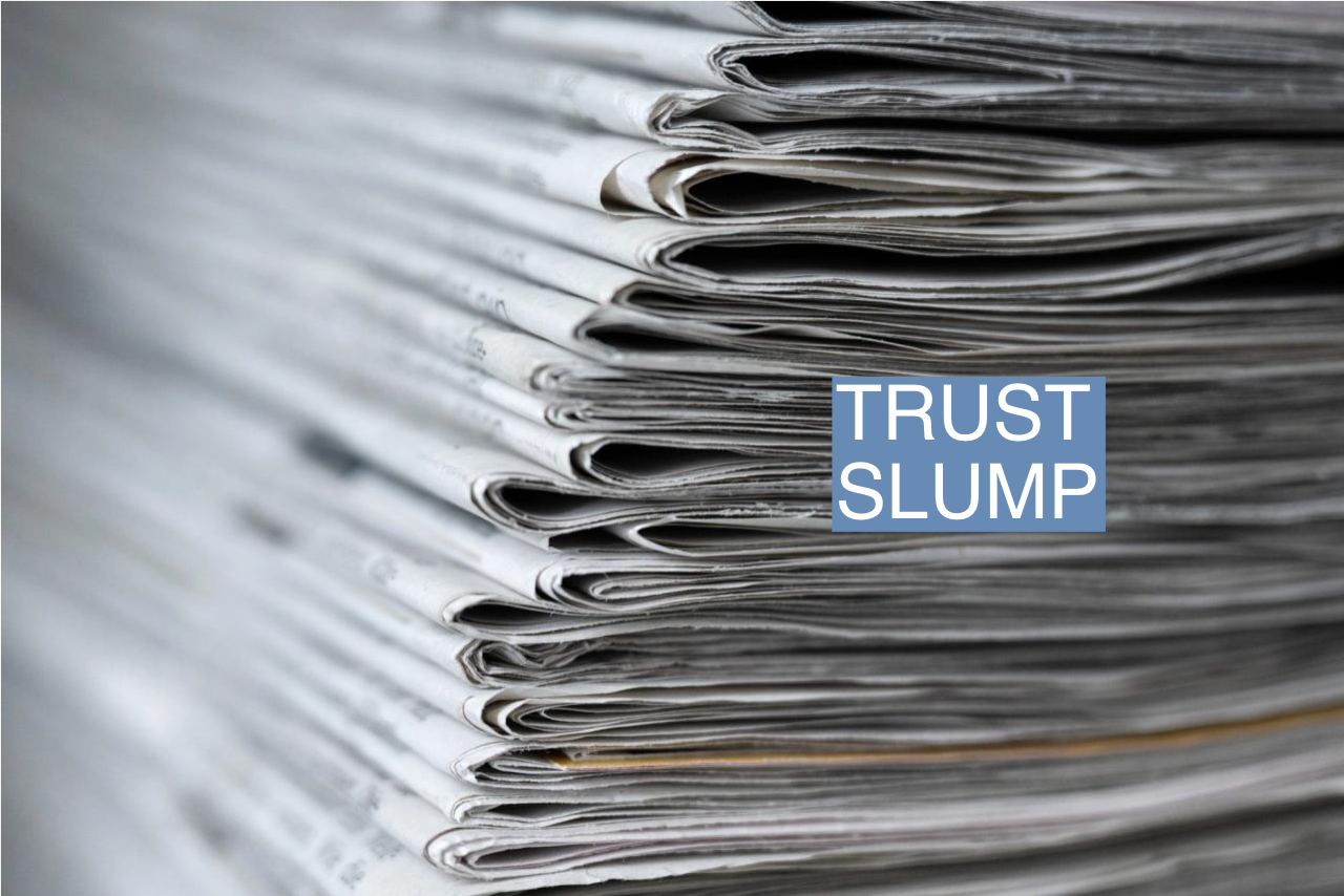 A stack of various daily newspapers lies on a table.