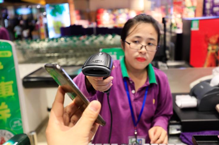 A local resident uses his smartphone to have the QR code scanned at a shopping mall in Shanghai, China, 26 September 2018.