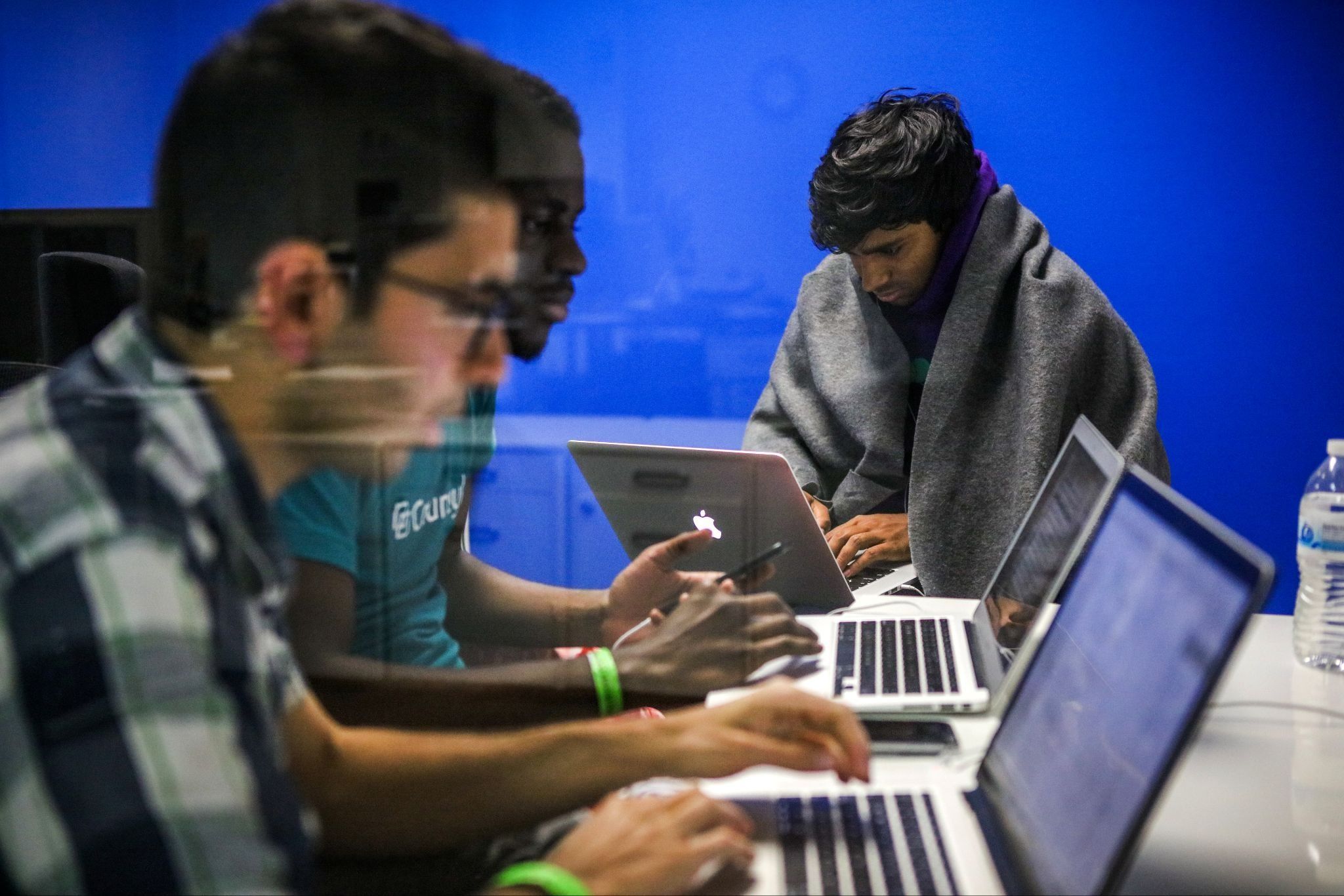Mehmet Efe Akengin, Hassan Kane and Surya Bhupatiraju (L-R) work late into the night on computers.  