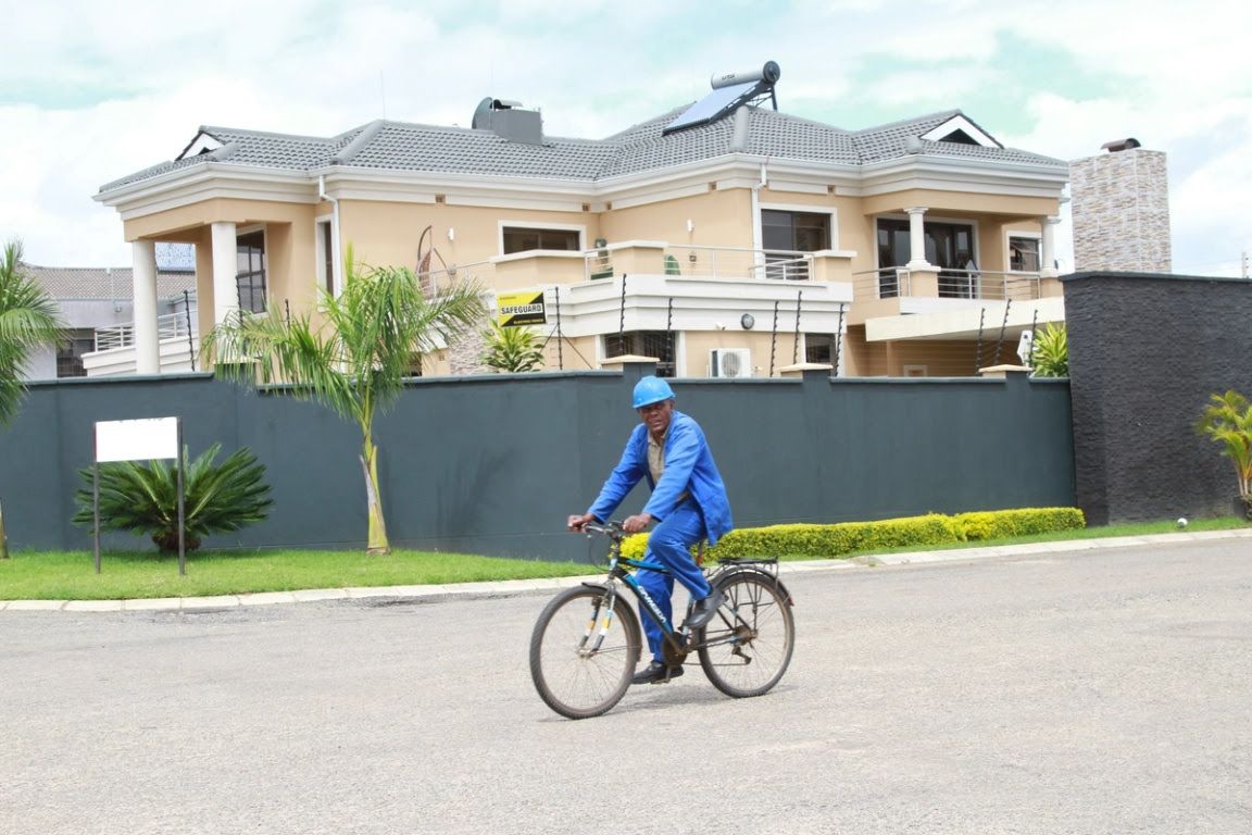 A man cycles past an upmarket housing development in Harare, Zimbabwe.