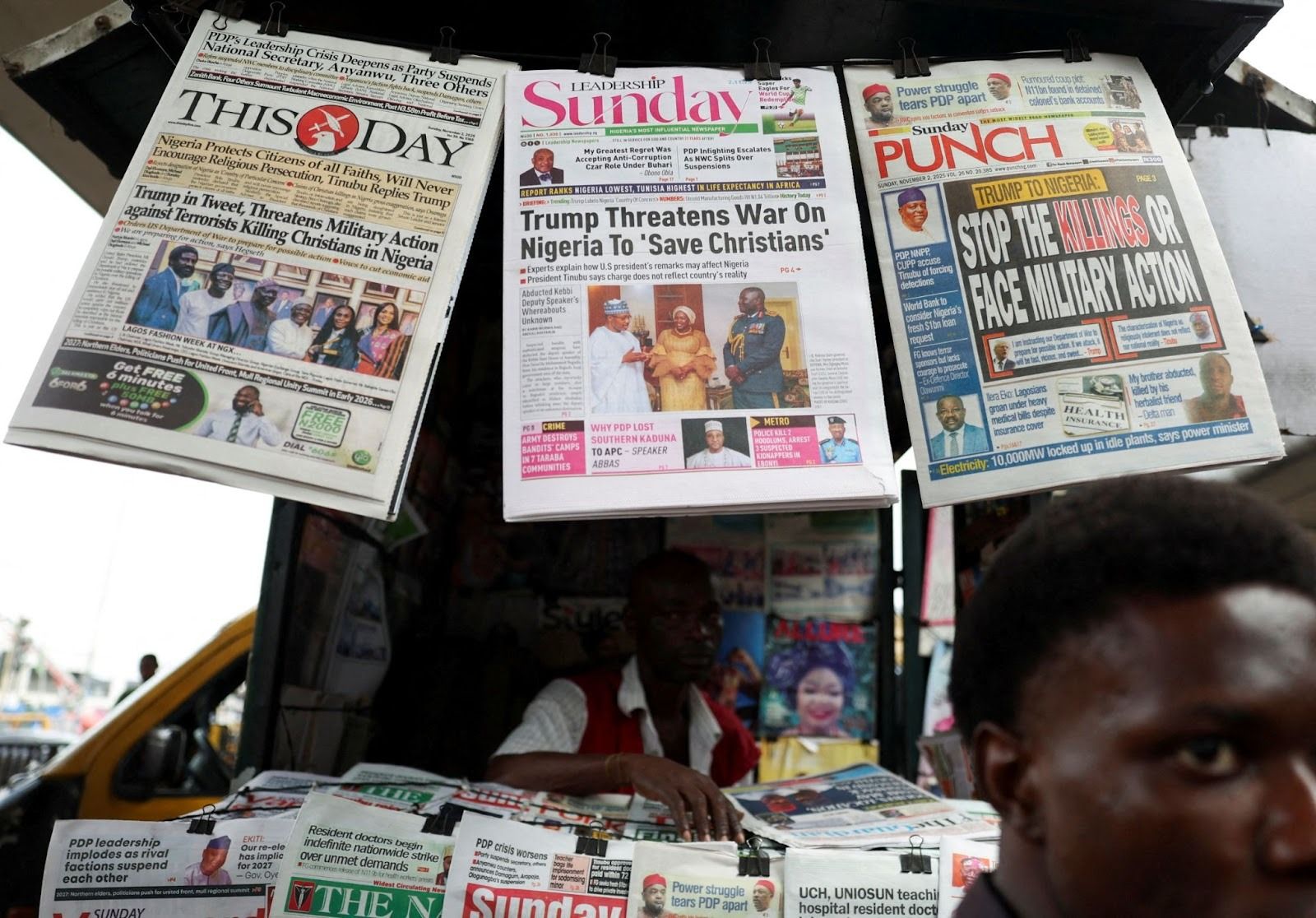 Newspapers reporting US President Donald Trump’s message to Nigeria over the alleged mistreatment of Christians hang at a newspaper stand in Lagos on Nov. 2, 2025.