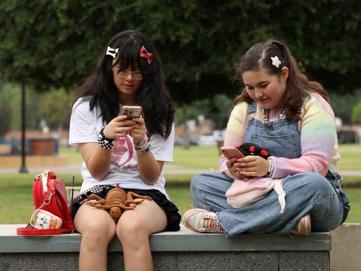 Annie Wang, 14, and Ayris Tolson, 15, pose after an interview discussing Australia’s social media ban for users under 16, which is scheduled to take effect on December 10, in Sydney, Australia