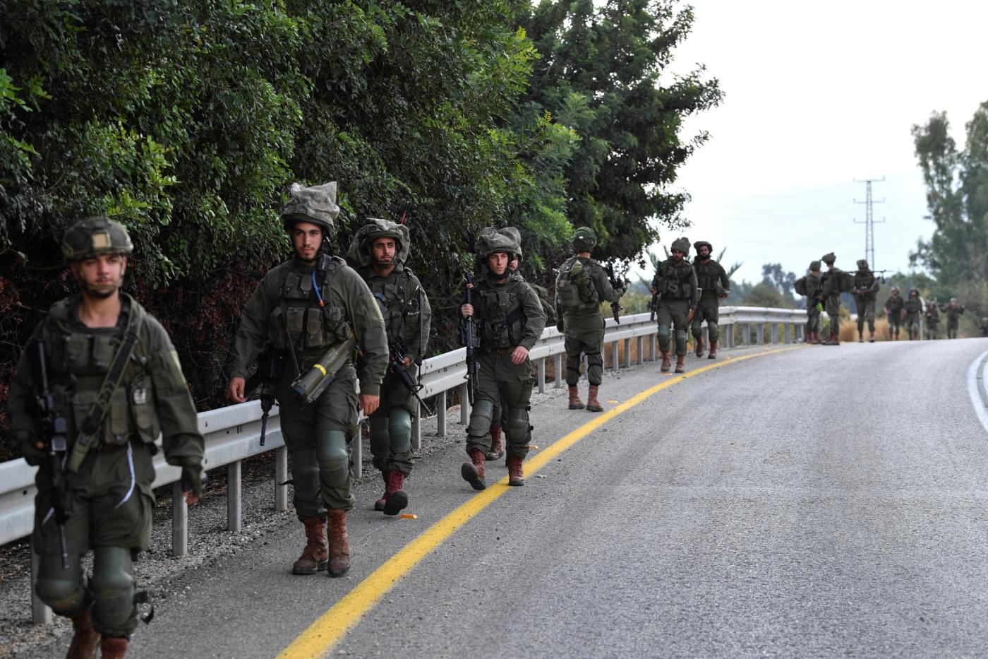 Israeli soldiers walk on a road near the Israel border with Lebanon amid heightened tensions between Israel and Lebanon, in northern Israel, October 19, 2023. 