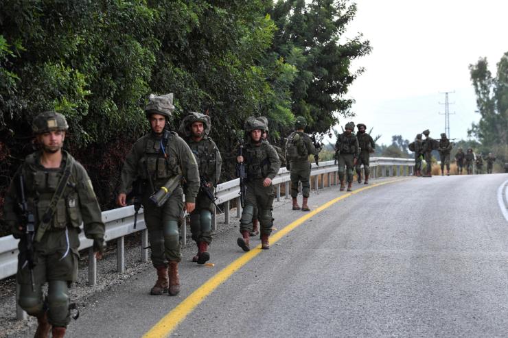 Israeli soldiers walk on a road near the Israel border with Lebanon amid heightened tensions between Israel and Lebanon, in northern Israel, October 19, 2023.