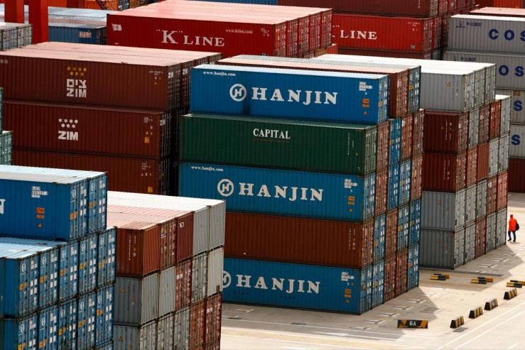 A man walks past containers at a port in Shanghai