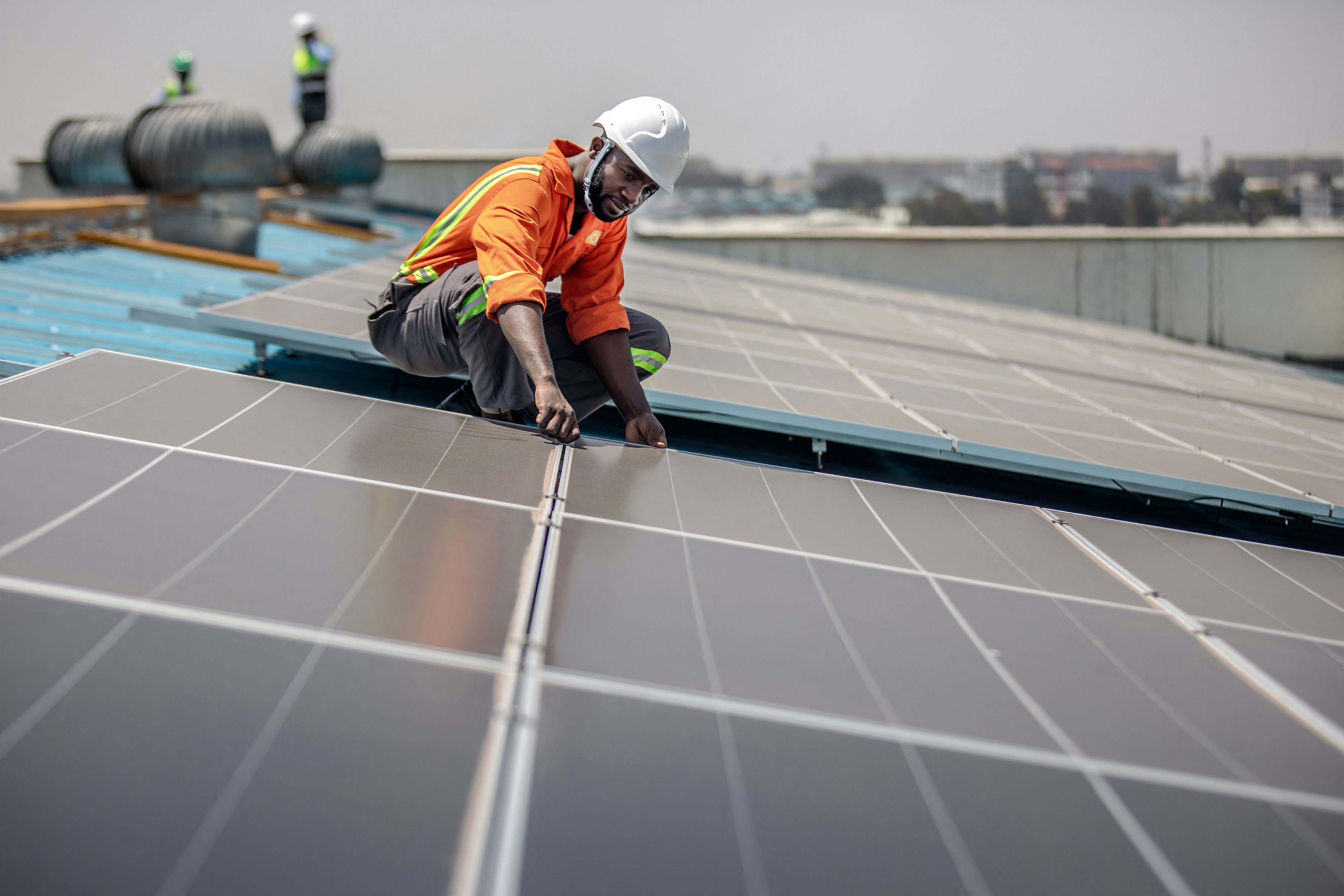 A technician installs solar panels in Kenya.