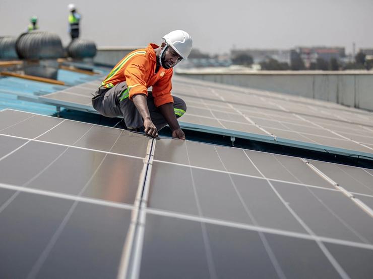 A technician installs solar panels in Kenya.