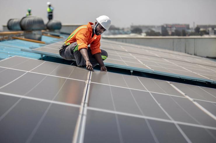 A technician installs solar panels in Kenya.