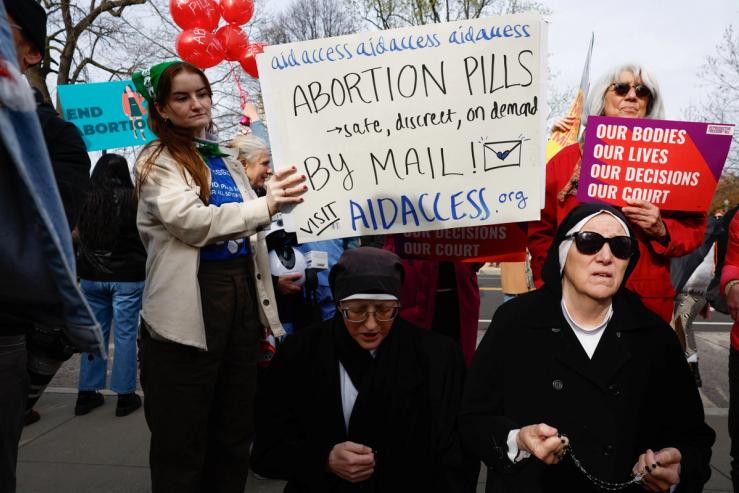 A demonstrator for abortion rights holds a placard during a protest outside the U.S. Supreme Court on March 26, 2024.