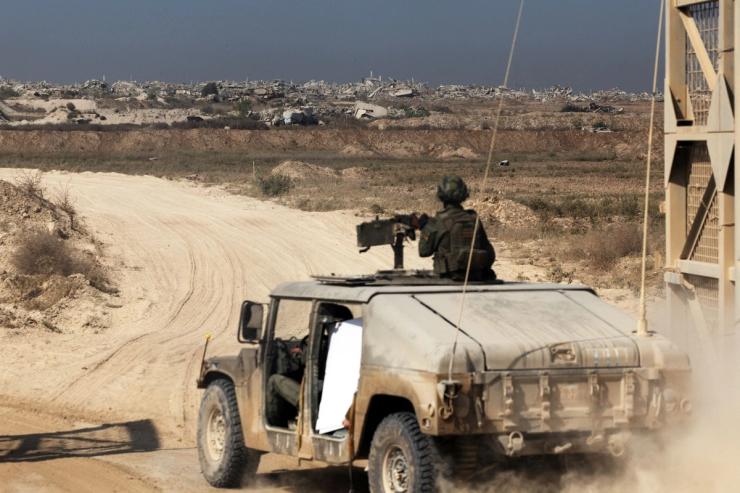 Israeli soldiers enter the Gaza Strip in a military vehicle from at the Israel-Gaza border