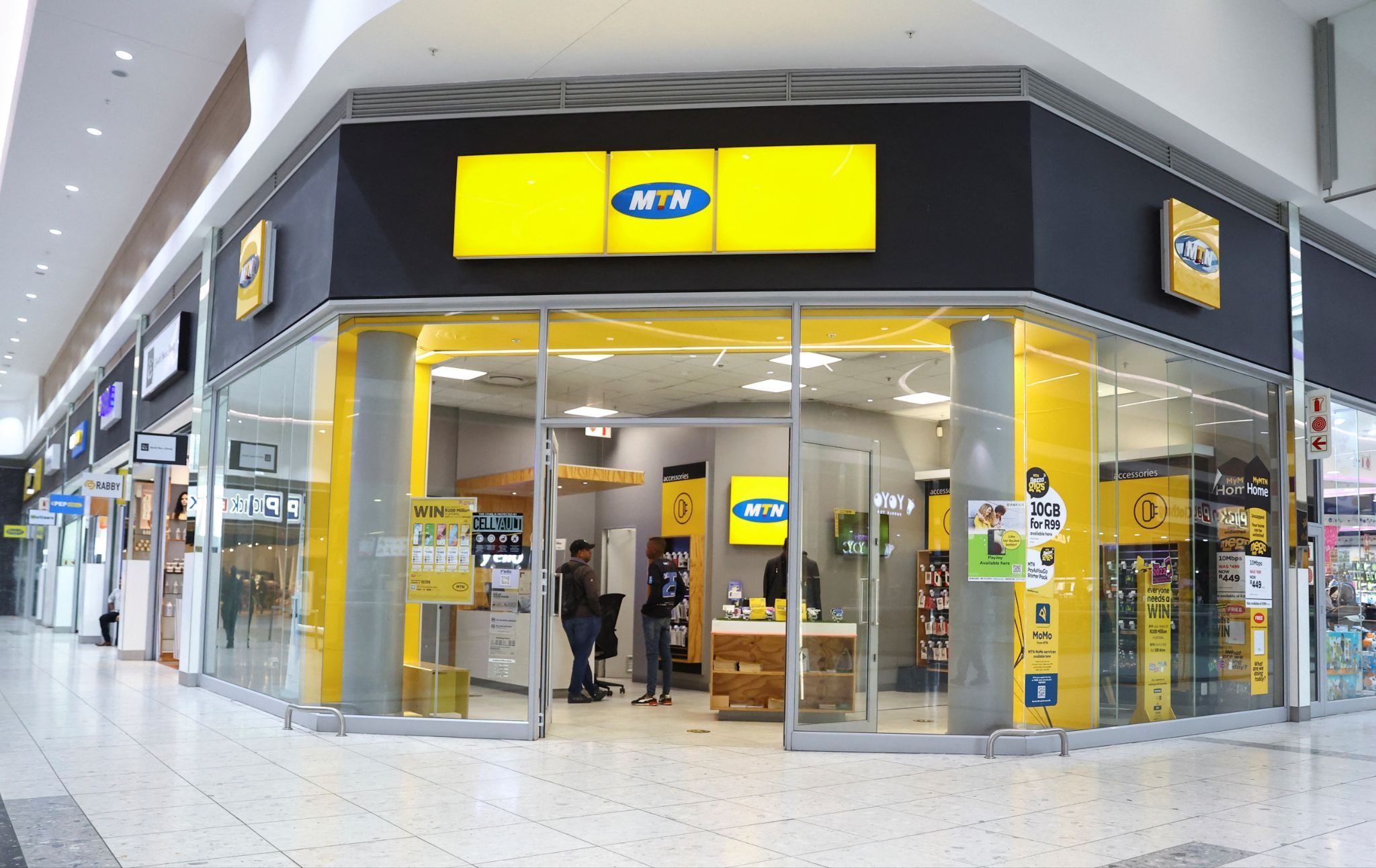 Customers are seen at an outlet of South Africa’s MTN Group at the Mall of the South in Johannesburg.