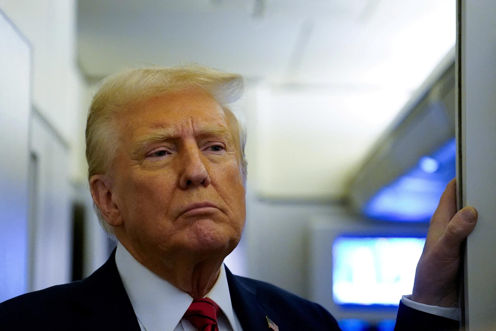 U.S. President Donald Trump speaks to reporters aboard Air Force One.