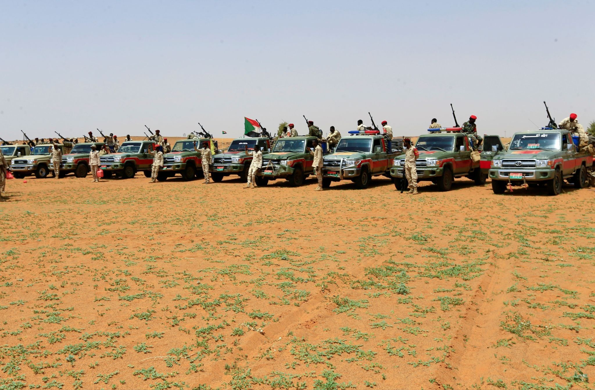 Members of Sudan’s paramilitary Rapid Support Forces (RSF) stand next to vehicles.