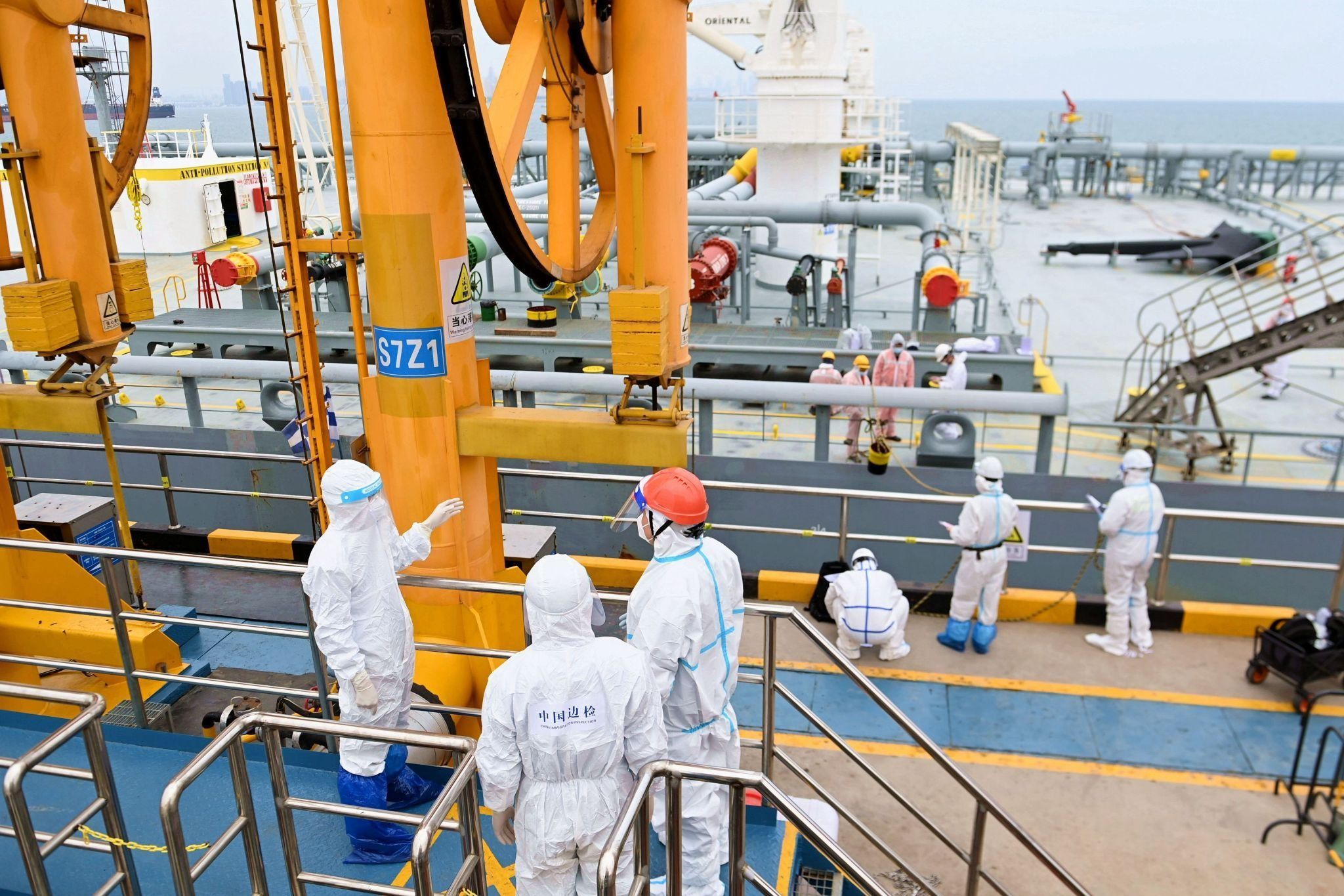 Immigration inspection officers check a tanker carrying imported crude oil at the port in Qingdao