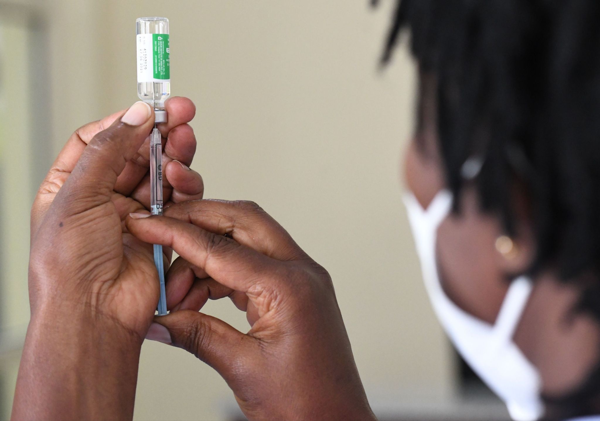 A Kenyan health worker prepares to administer a vaccine.