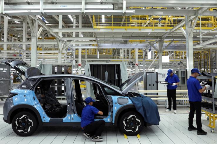 Workers assemble an EV car inside a BYD factory in Thailand