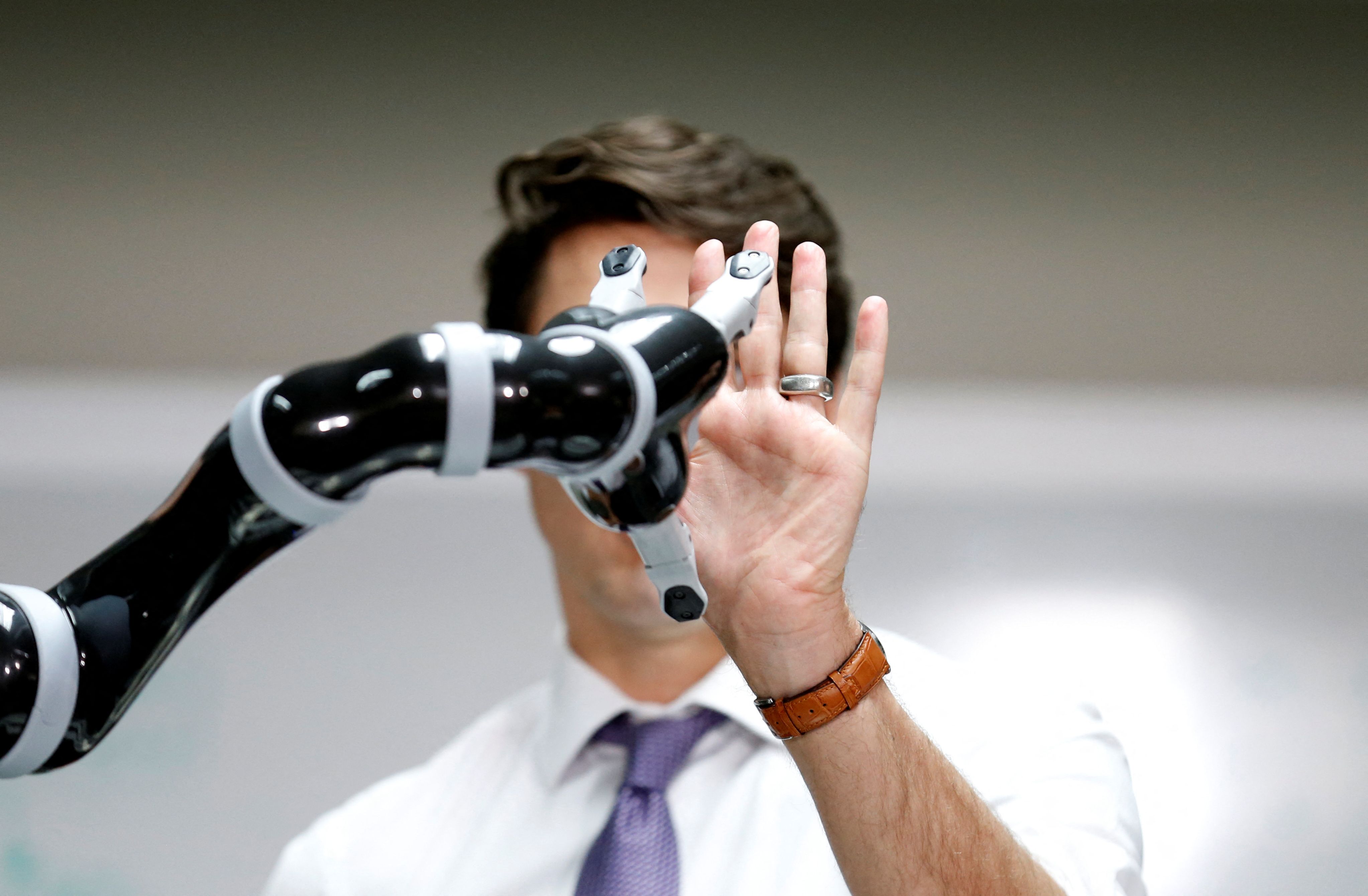 Canadian PM Justin Trudeau touches a robotic arm made by Kinova Robotics. 