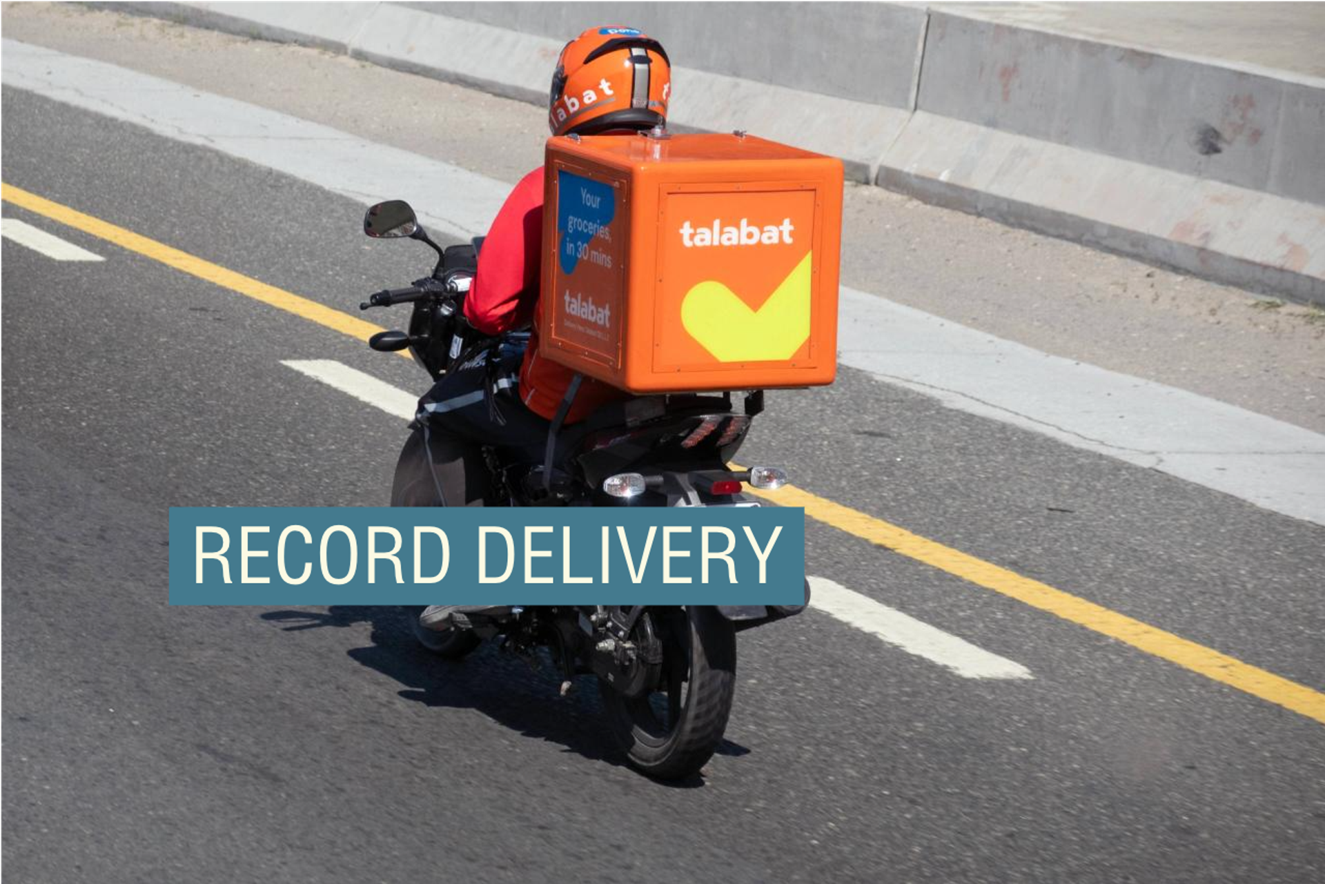 A Talabat employee rides his motorbike