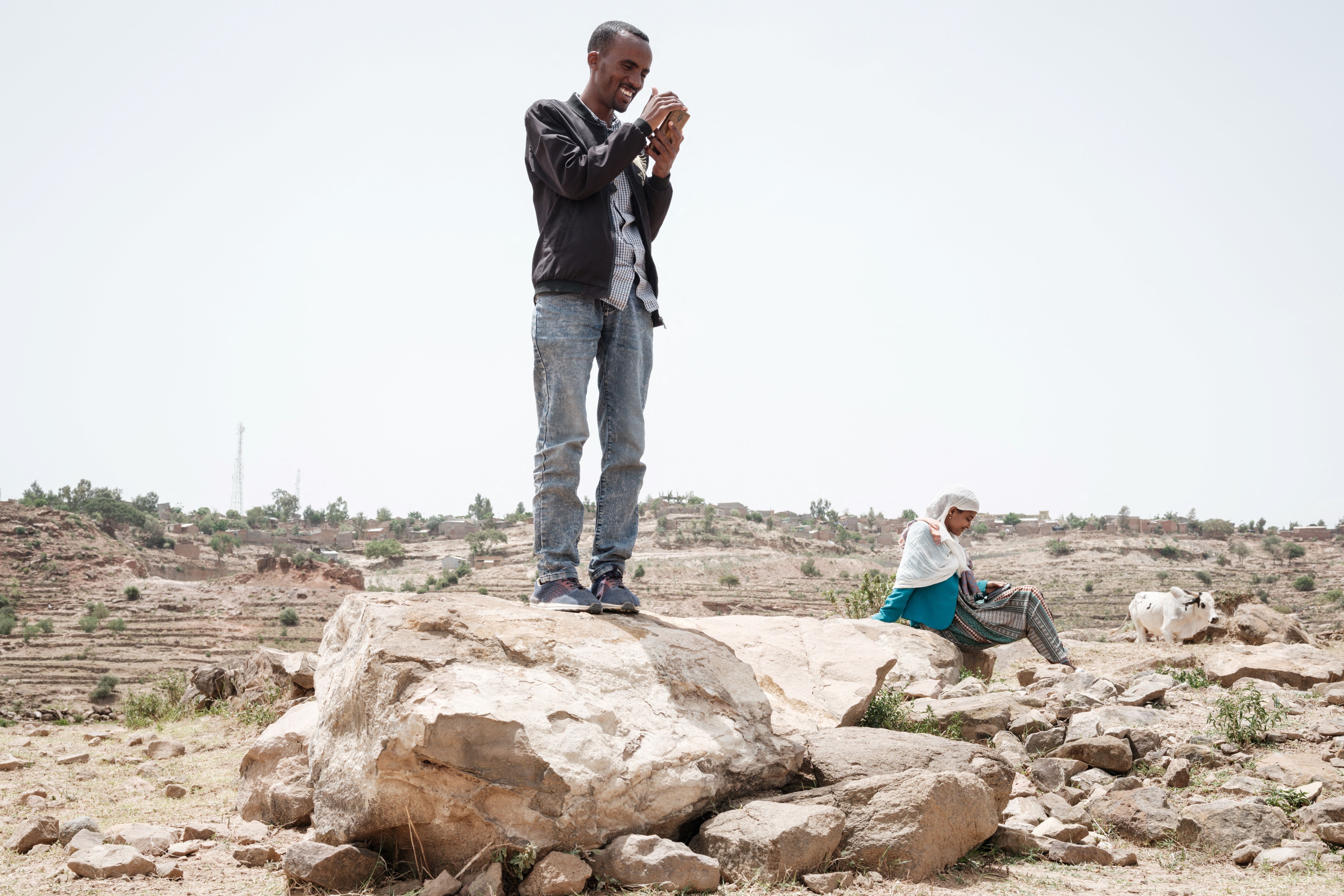 People try to reach mobile phone signal after most of an area is in blackout in Tigray in June 2021.