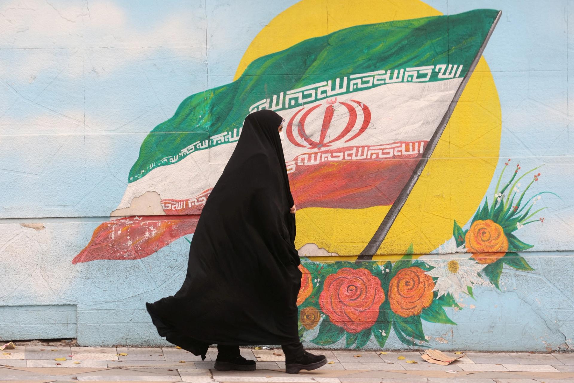 A woman walks after the morality police shut down in a street in Tehran, Iran.