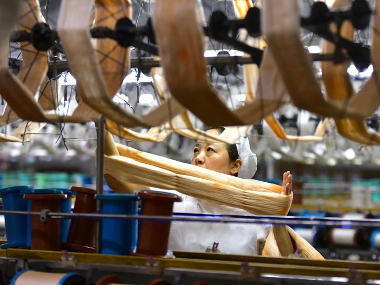 An employee works on a silk textile production line at a factory in Fuyang, Anhui province, China Oct. 19, 2026