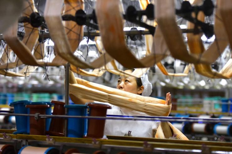 An employee works on a silk textile production line at a factory in Fuyang, Anhui province, China Oct. 19, 2026