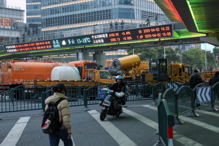 An electronic board shows stock indices at the Lujiazui financial district in Shanghai, China April 2, 2025.