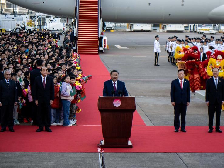 Xi Jinping lands in Macau and makes an address, flanked by officials of Macau.