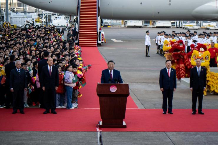 Xi Jinping lands in Macau and makes an address, flanked by officials of Macau.